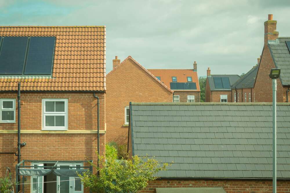 Photo of a group of houses with solar panels on their rooves